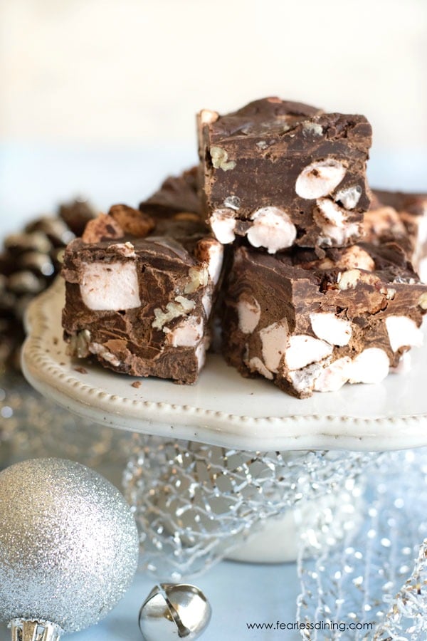 peppermint rocky road fudge stacked on a dessert table with ornaments around it