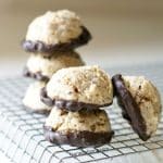 The gluten-free chestnut cookies dipped in chocolate on a rack.