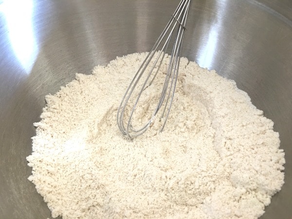 The eggnog cookies dry ingredients in a bowl with a whisk.