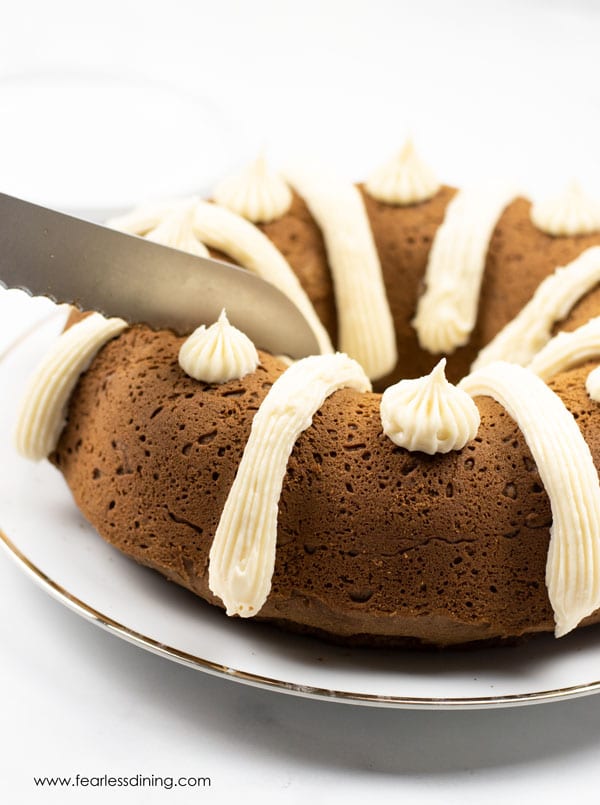 A knife cutting into a gluten free gingerbread bundt cake.