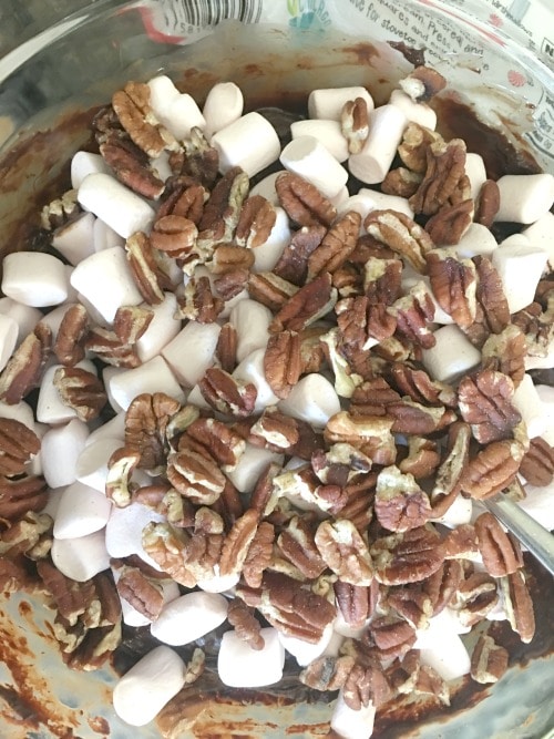marshmallows and pecans on top of melted chocolate