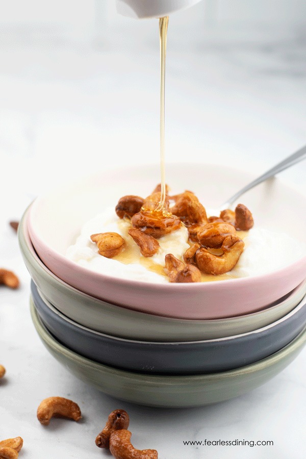 Drizzling honey into a bowl of yogurt.