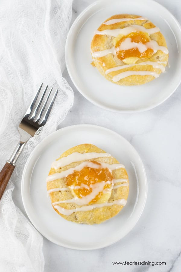 The top view of two gluten free danish pastries on white plates.