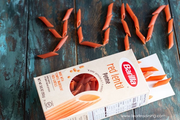 yum spelled out with red lentil pasta pieces