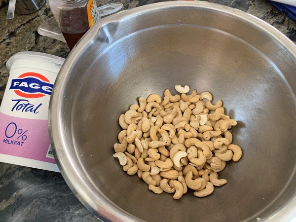 A big metal bowl full of cashews.