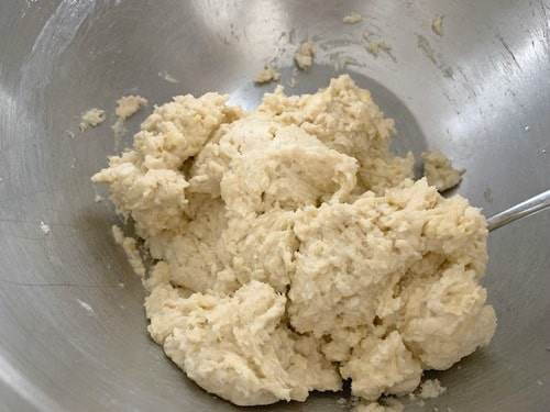 Biscuit dough in a silver mixing bowl.