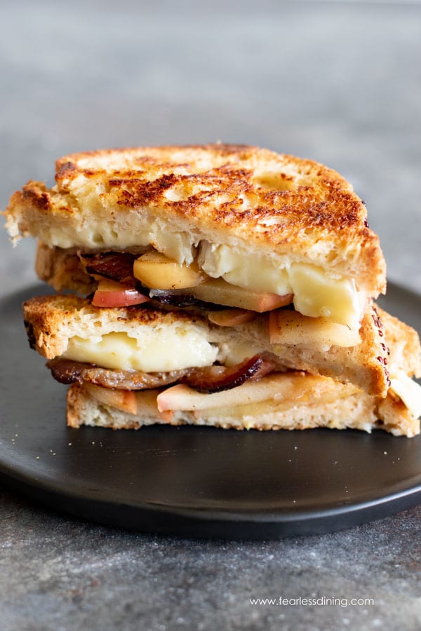 a grilled brie cheese sandwich cut in half and stacked on a plate.