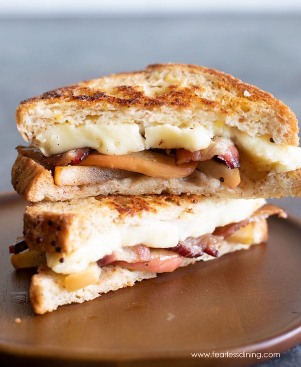 grilled cheese with brie and apple on a wooden plate