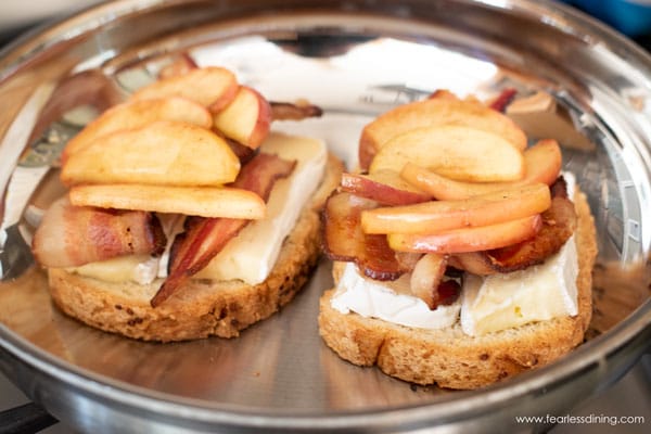 bacon and apple layers added to grilled brie sandwich