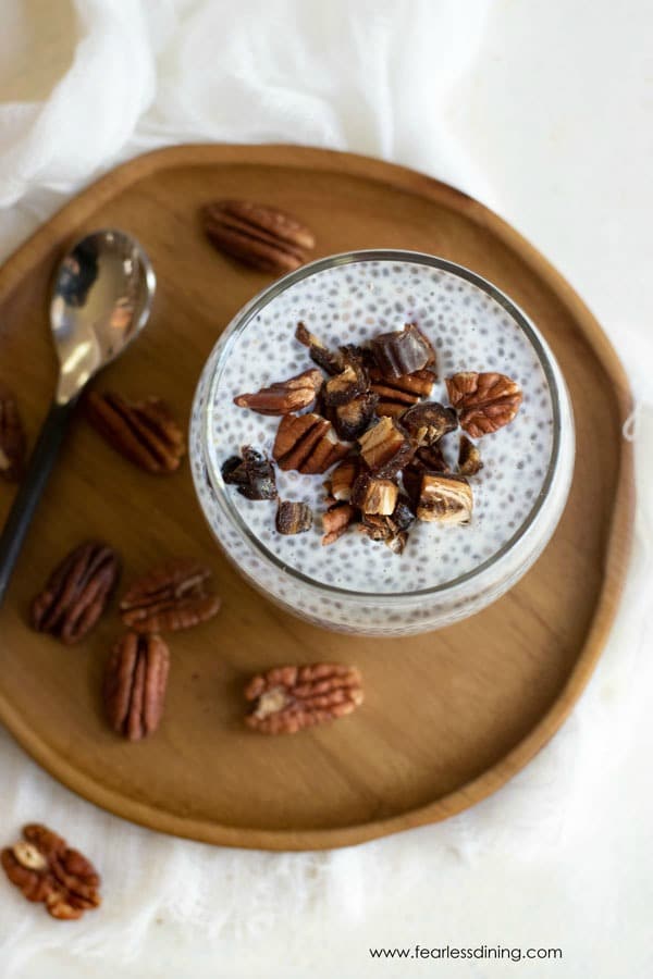 top view of vanilla chia seed pudding in a glass with pecans around the plate