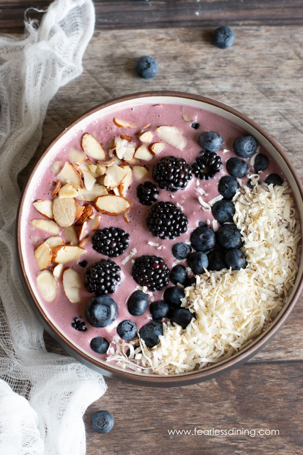 top view of an Acai bowl. The smoothie bowl is topped with blueberries, blackberries, almonds and coconut