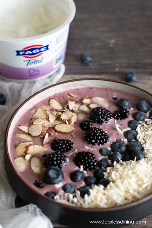 An acai bowl next to a FAGE yogurt container.