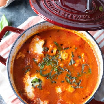 A red Dutch oven filled with cooked shakshuka.