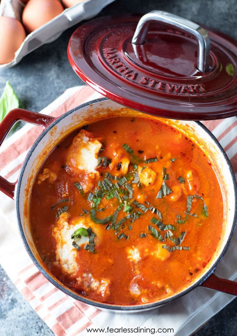 A red Dutch oven filled with cooked shakshuka.