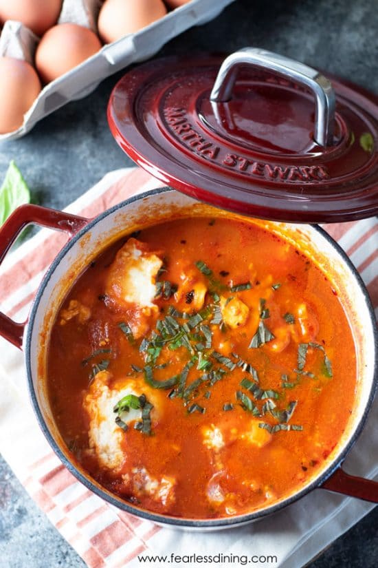 A small red Dutch oven filled with shakshuka.