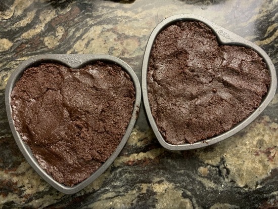 Gluten free brownie batter in heart shaped cake pans.