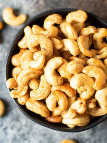 A closeup of a bowl of honey roasted cashews.
