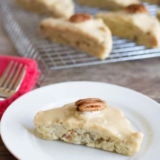 A gluten-free maple bacon scone on a small white plate.