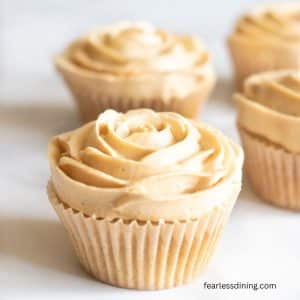 Frosted gluten free caramel cupcakes on a tray.