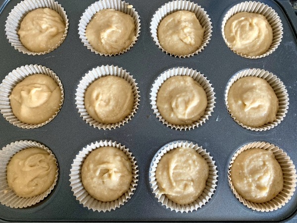 Cupcake batter in a lined muffin tin ready to bake.