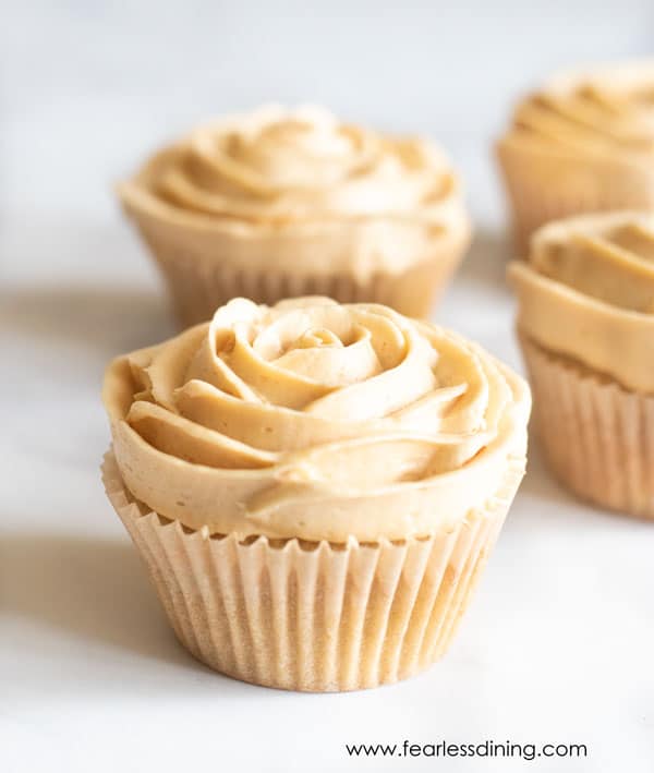A close up of a caramel cupcake with frosting like a rose.