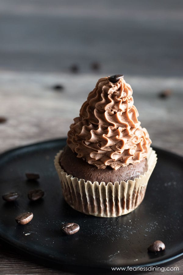 a picture of a gluten free mocha cupcake on a dark wooden plate