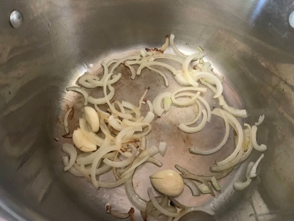 The onions and garlic sauteing in a pan.