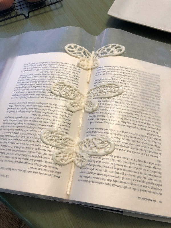 Three white chocolate dragonflies hardening.