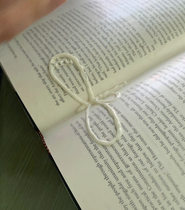 Making an outline of dragonfly wings out of white chocolate.