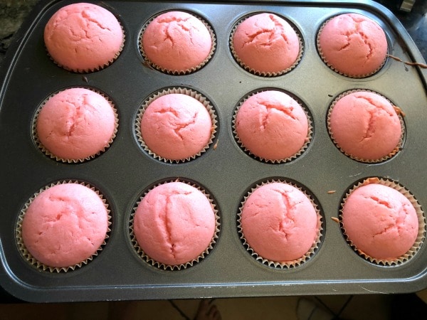 baked pink cupcakes in a muffin tin.