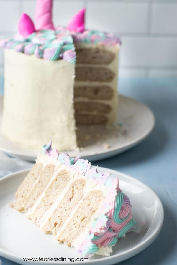 A slice of the gluten free unicorn cake with the cake in the background.