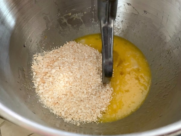 The eggs and wet ingredients in a mixer. Matzo meal is poured and ready to mix in.