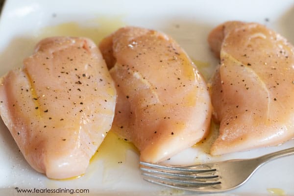 Photos of the seasoned chicken breasts on a plate.