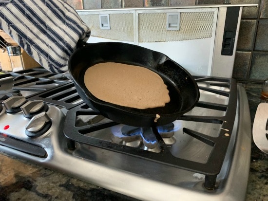 tilting the crepe pan to spread the batter