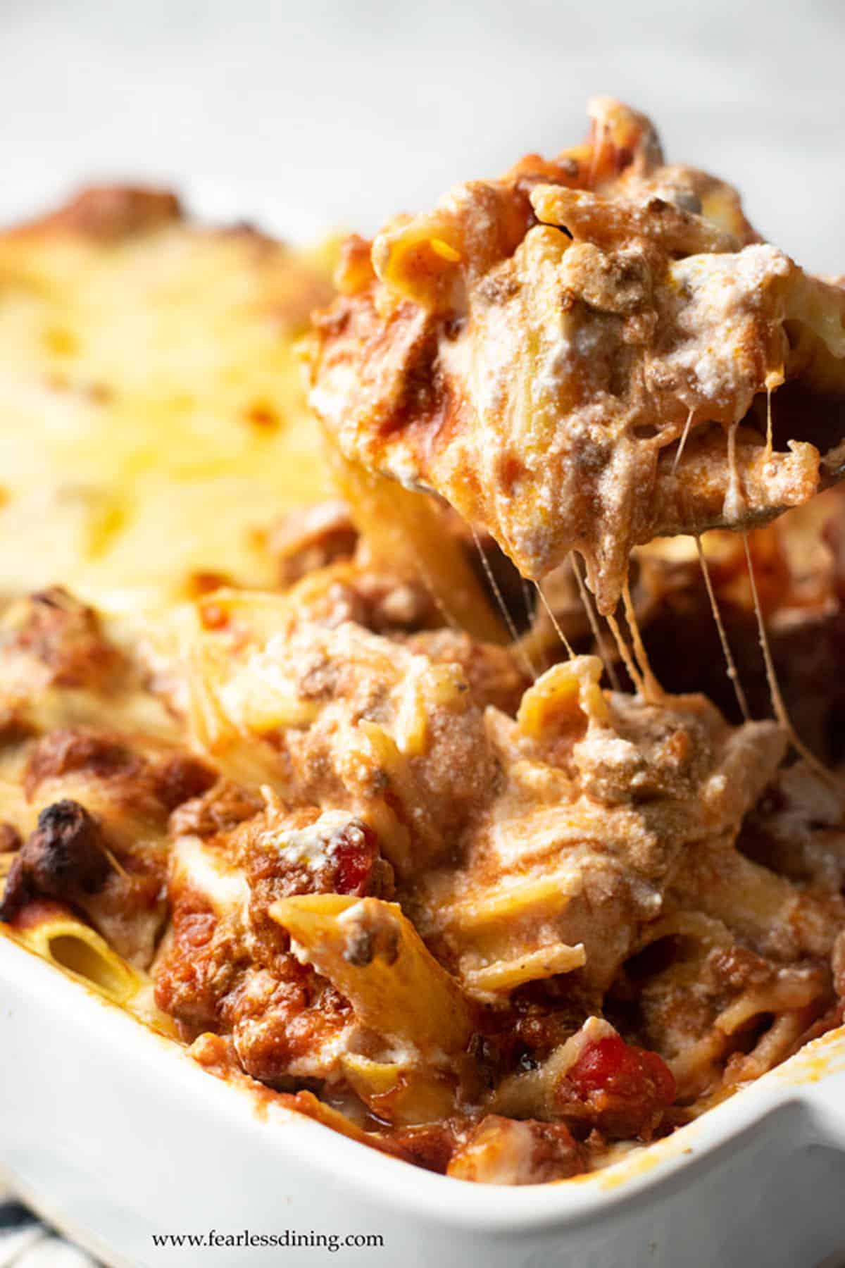 A serving spoonful of baked ziti casserole.