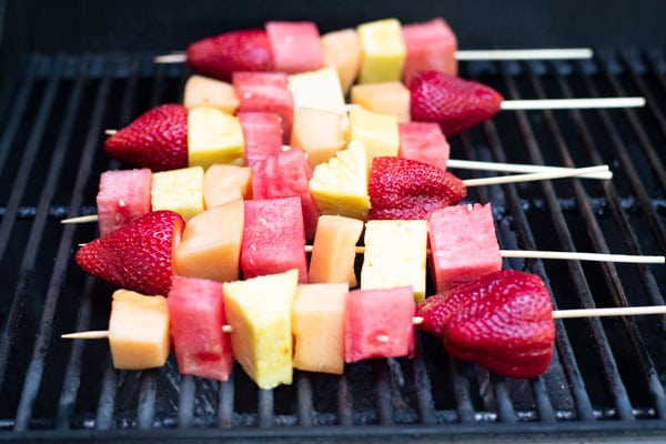 The fruit kabobs on a grill.