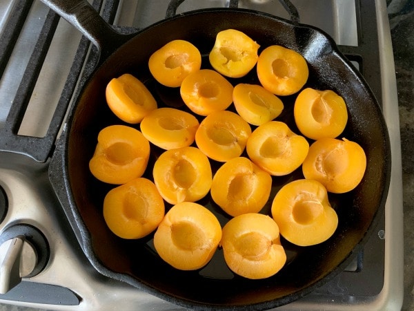 The apricot halves in a cast iron skillet.