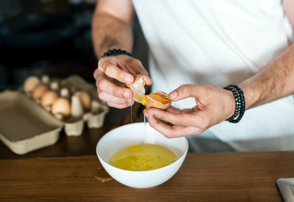 Separating egg whites into a bowl.