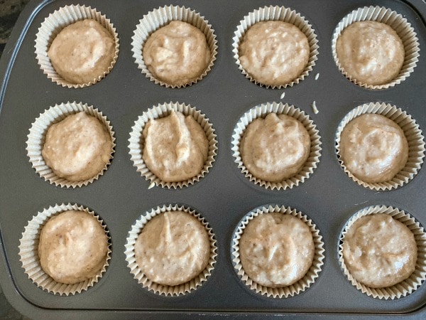 The churro muffin batter in a muffin tin.