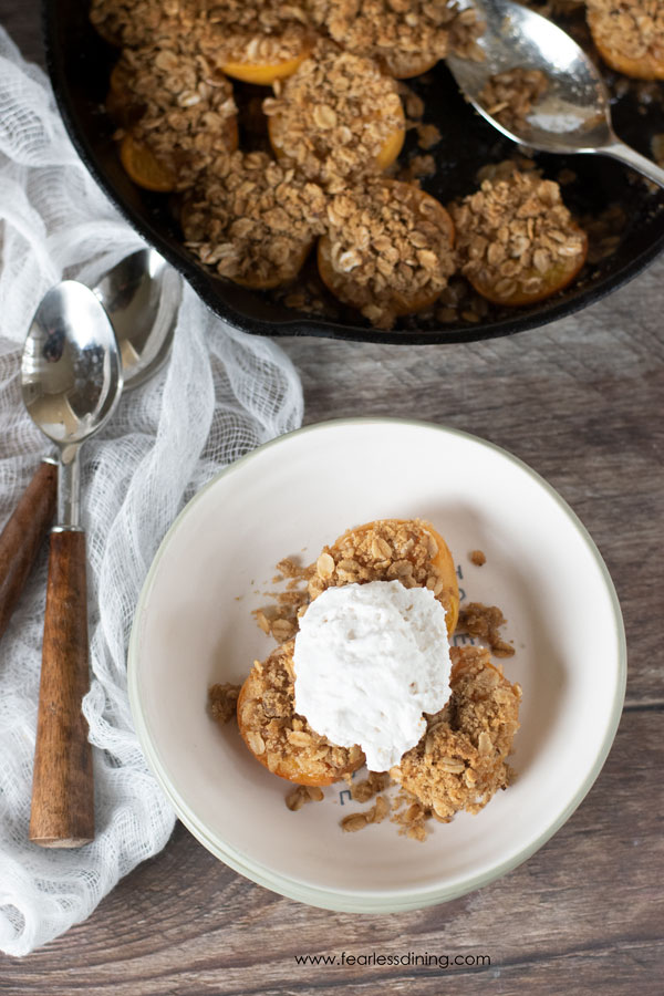 The top view of a bowl of apricot crisp with the pan of crisp next to it.