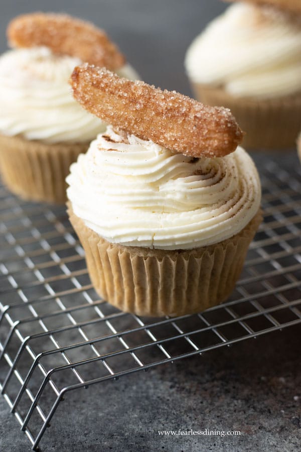 Gluten free churros cupcakes on a rack.