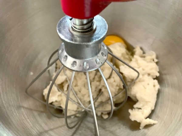 Churro dough and eggs in a mixer.