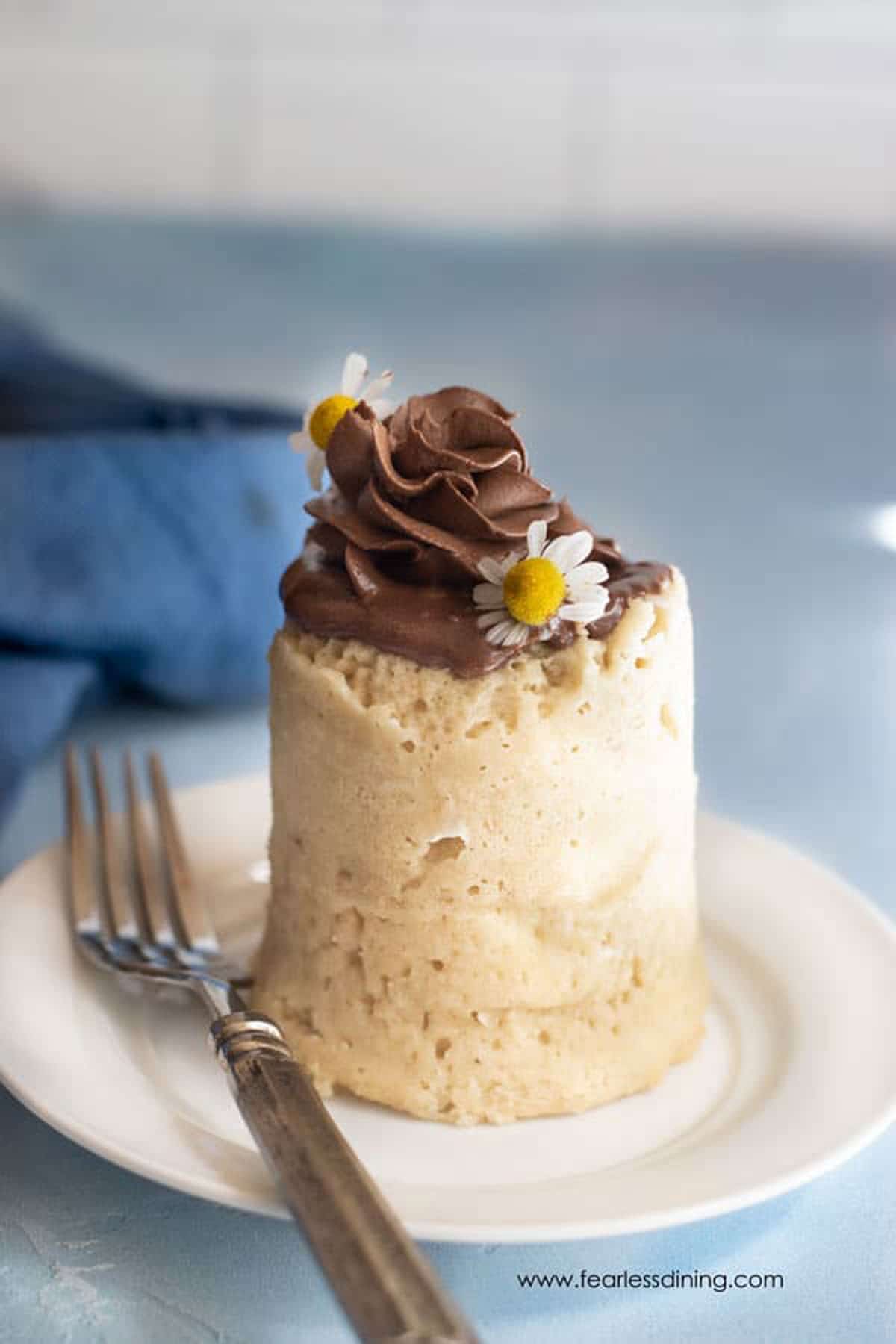 A single serving gluten free vanilla mug cake on a white plate.