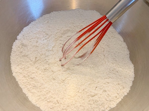 dry ingredients in a bowl with a red whisk