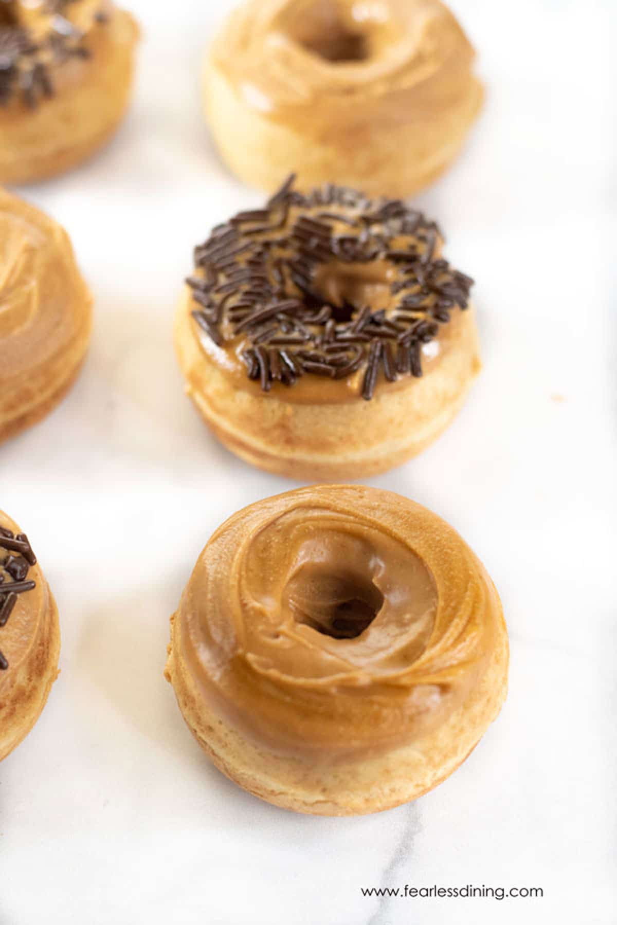 Rows of mini gluten free peanut butter donuts.