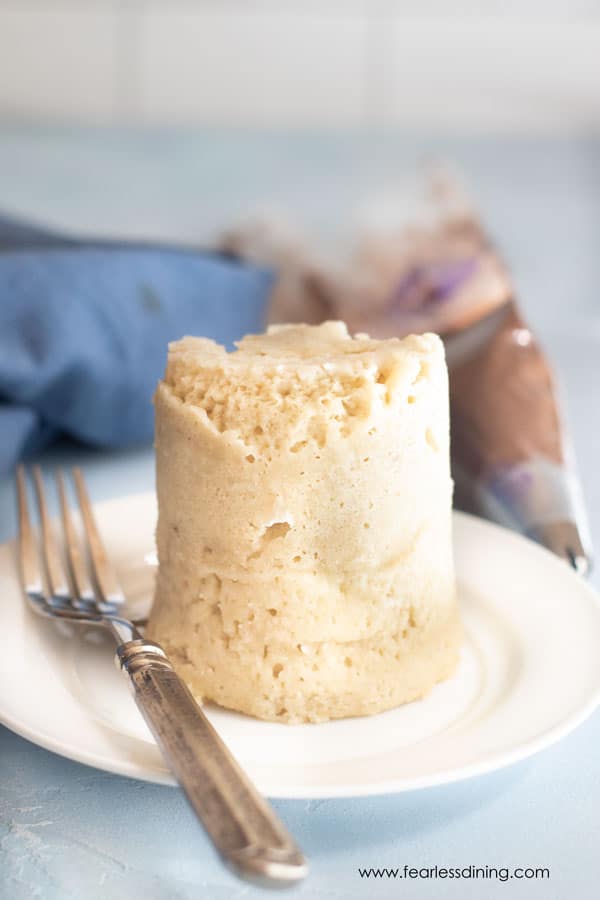 A vanilla mug cake turned upside down on a plate.