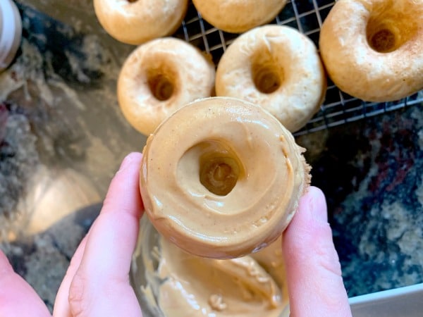 holding up a donut with peanut butter icing