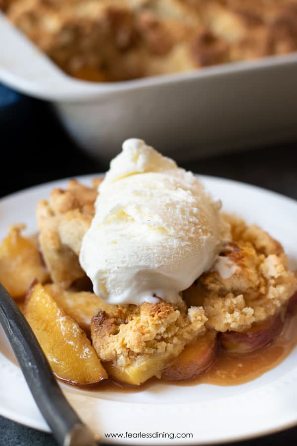 A close up of the paleo peach cobbler with ice cream topping.