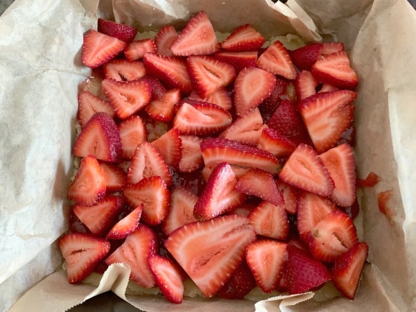 The sliced strawberries on the crust layer.