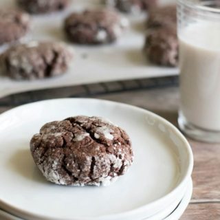 A brookie cookie on a stack of white plates next to a glass of milk.
